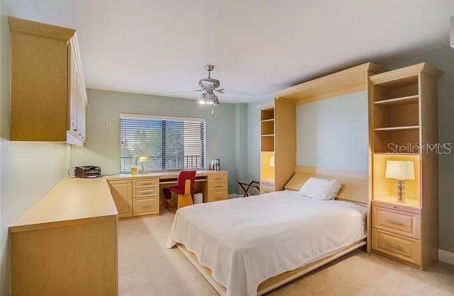 5911 Midnight Pass Road, Unit 601 Sarasota, FL 34242 - Photo 6 of 48 a bedroom with a bed a table and chandelier