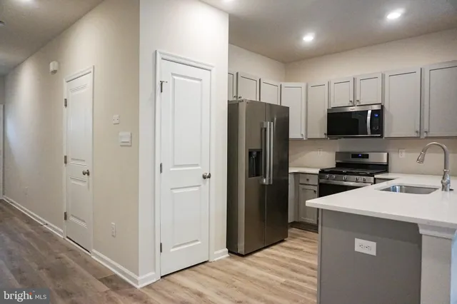a kitchen with stainless steel appliances a refrigerator and a stove top oven
