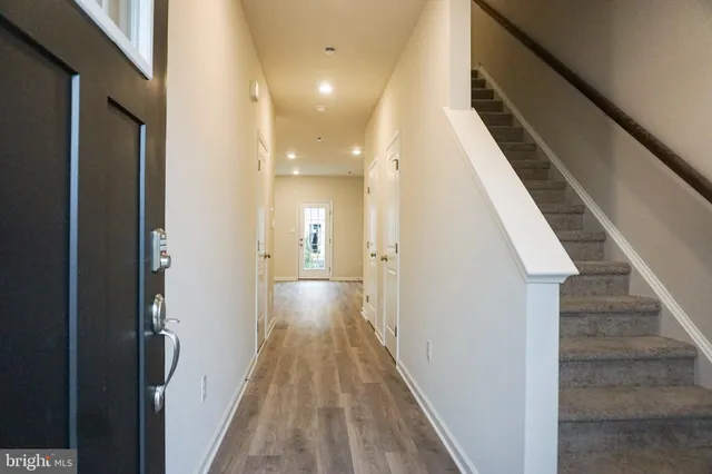 a view of a hallway with wooden floor and staircase