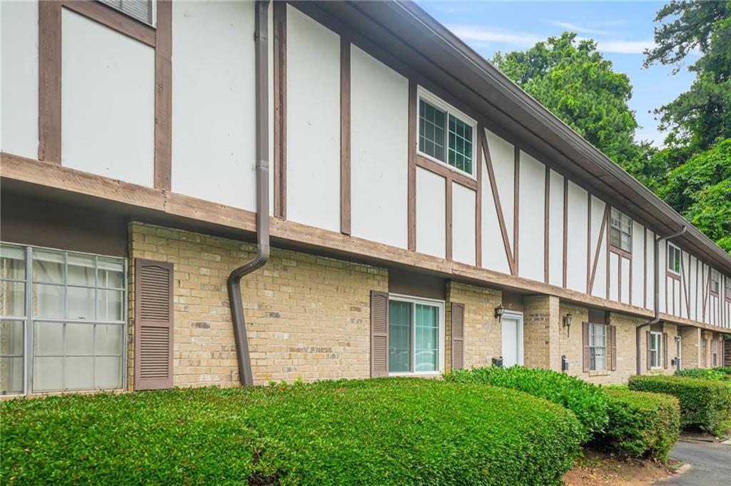 2952 North Dekalb Drive, Unit C Atlanta, GA 30340 - Photo 3 of 27 a view of a house with brick walls and a yard with plants