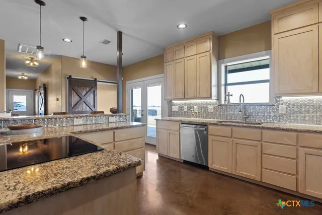 a large kitchen with granite countertop a sink window and stainless steel appliances