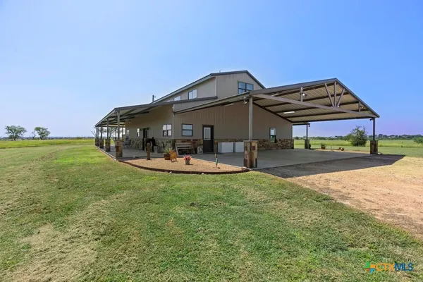 a view of a house with backyard and sitting area