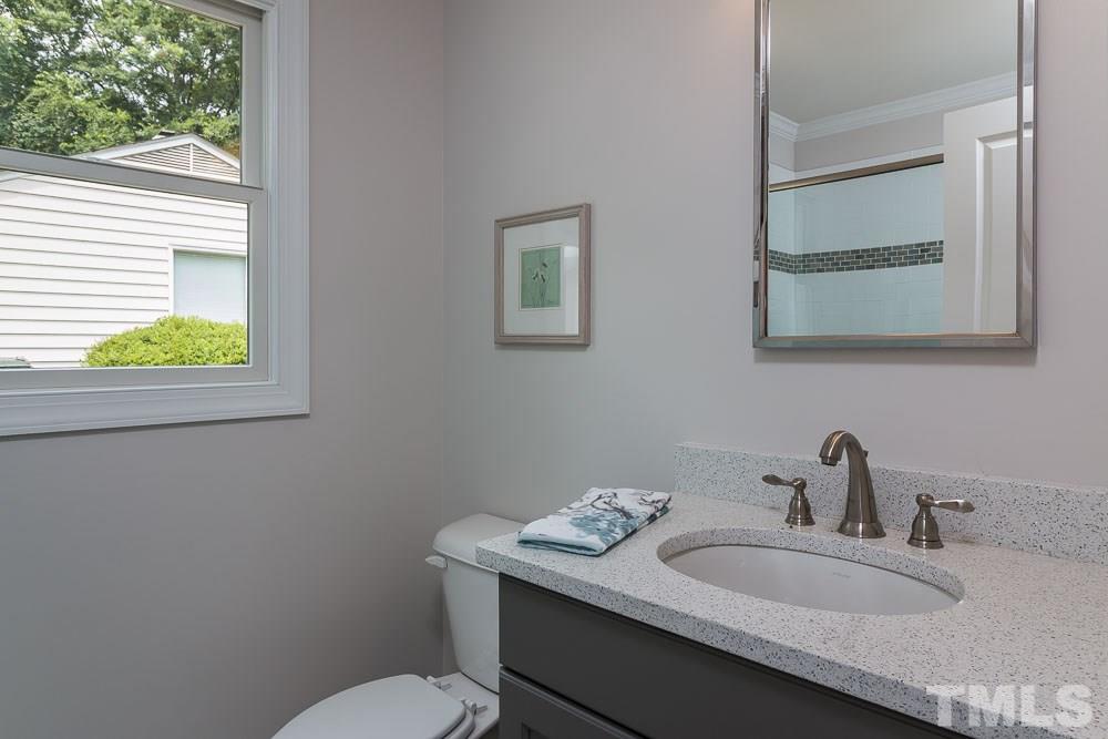 3411 Leonard Street Raleigh, NC 27607 - Photo 19 of 25 a bathroom with a toilet sink and mirror