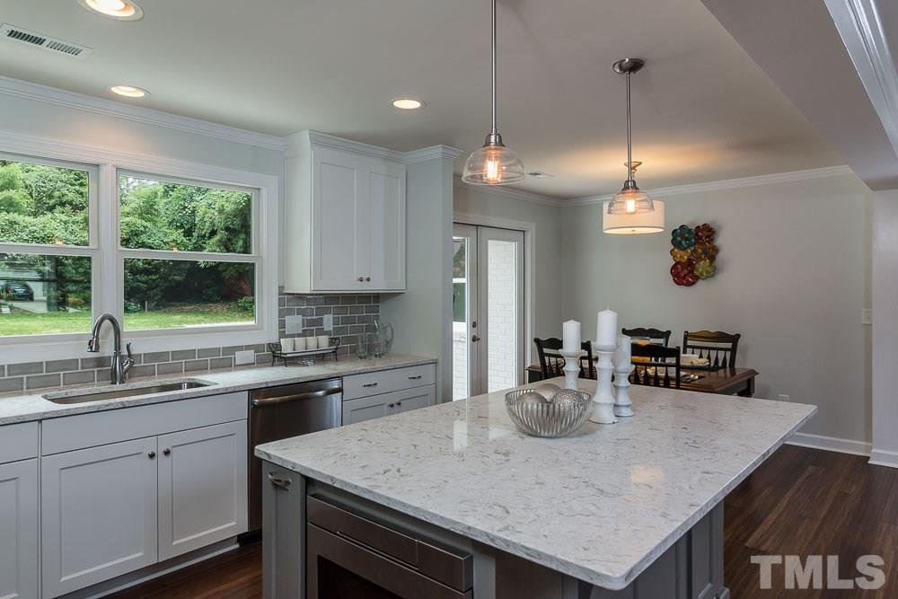 3411 Leonard Street Raleigh, NC 27607 - Photo 25 of 25 a kitchen with kitchen island a sink dining table and chairs
