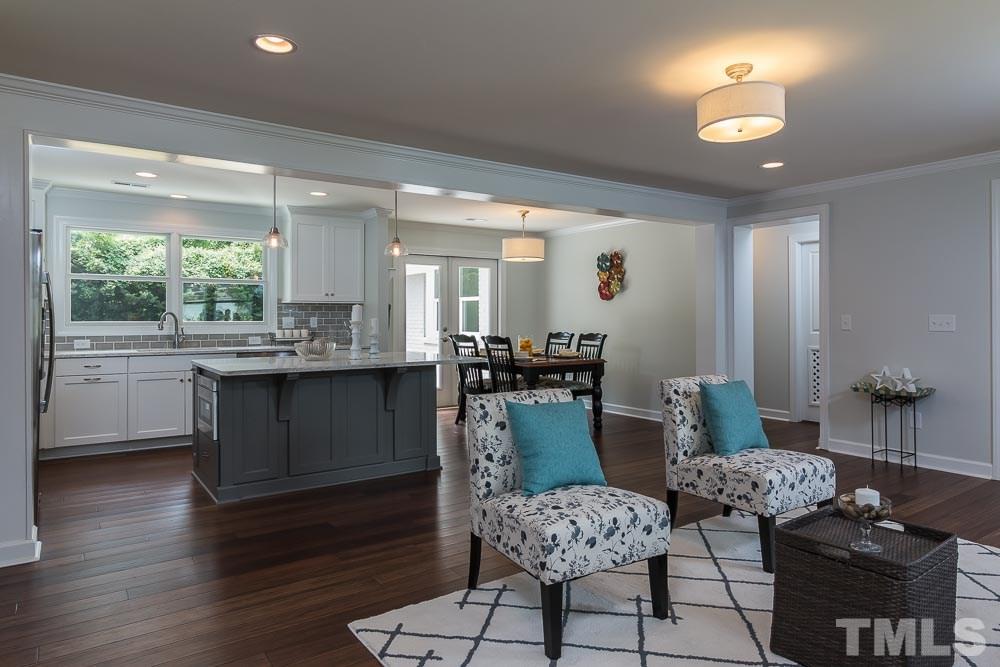 3411 Leonard Street Raleigh, NC 27607 - Photo 6 of 25 a kitchen with stainless steel appliances kitchen island granite countertop a stove a sink a dining table and chairs with wooden floor