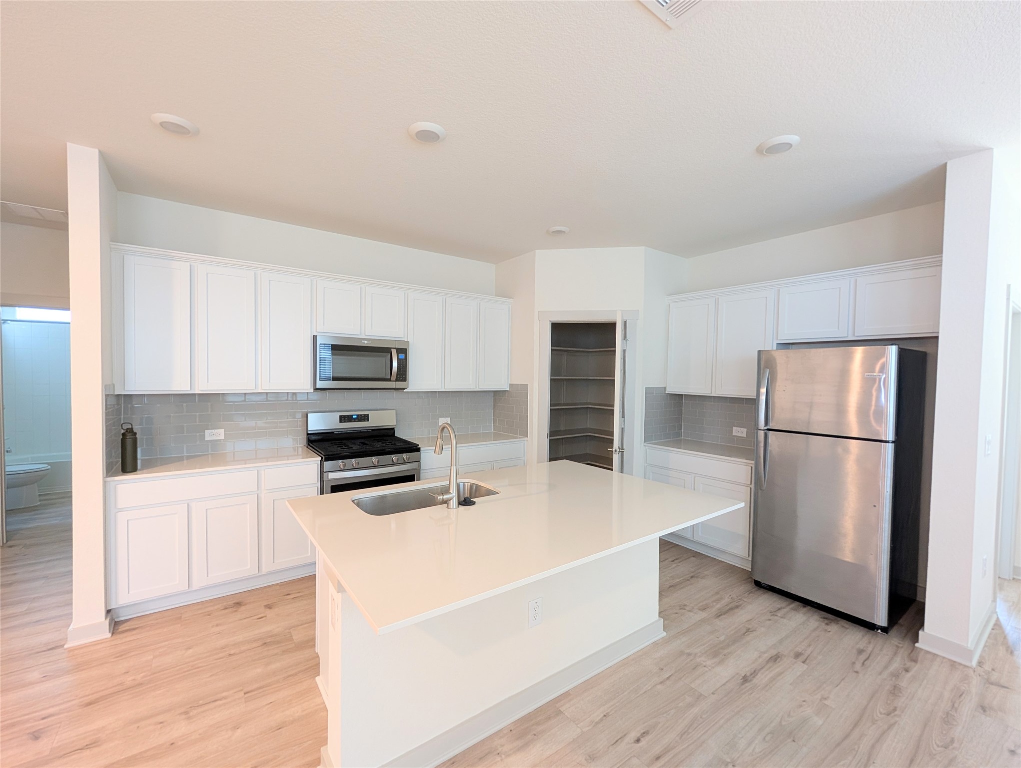 261 Century Plant Road Leander, TX 78641 - Photo 3 of 25 Bright, white cabinetry and stainless steel appliances complete this modern culinary space.