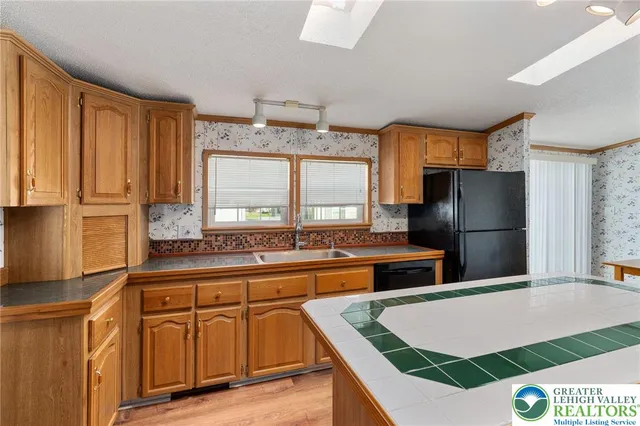 a kitchen that has a lot of cabinets a sink and appliances in it