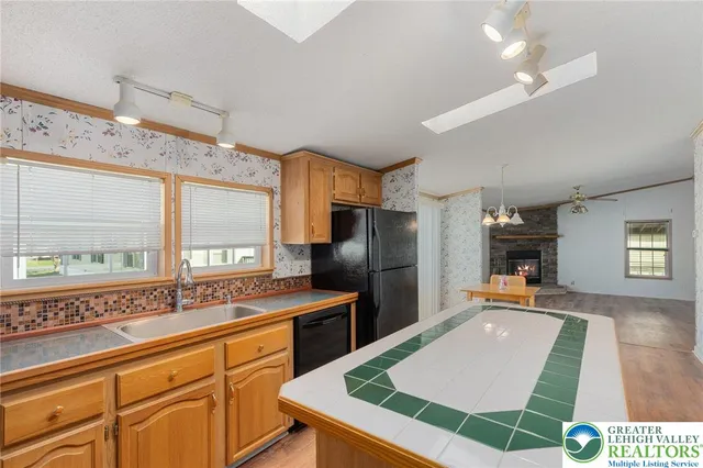 a kitchen with a refrigerator a kitchen island a sink and wooden floor