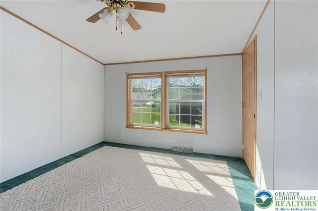 an empty room with windows and fan