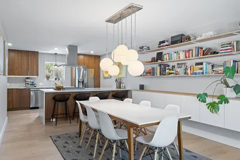 a dining room filled chandelier and a book shelf