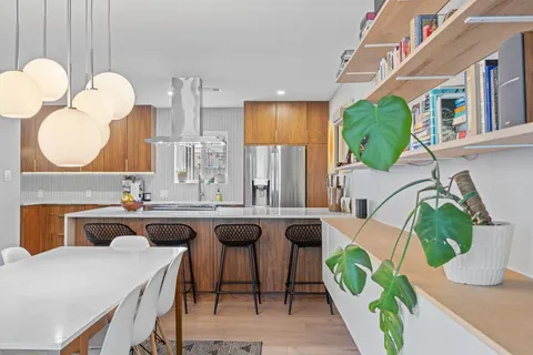 a kitchen with a table chairs sink and wooden floor