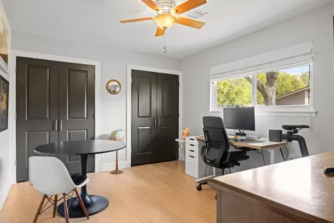 a view of a workspace with furniture and a window