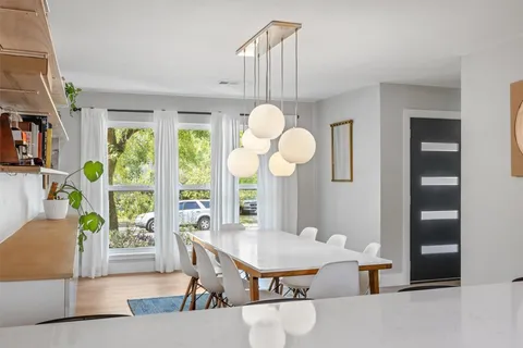a view of a dining room with furniture a chandelier and wooden floor