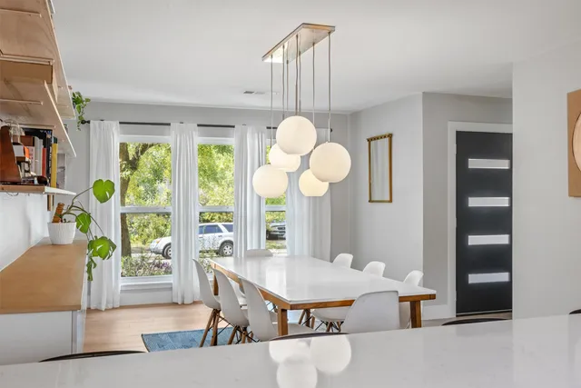 a view of a dining room with furniture a chandelier and wooden floor