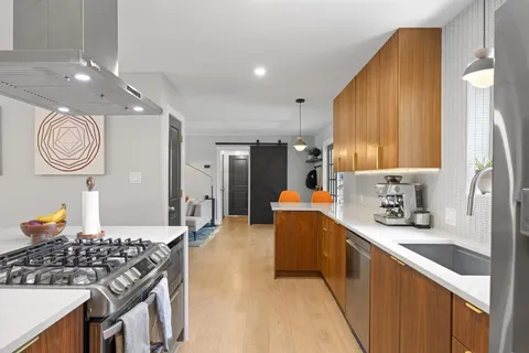 a kitchen with stainless steel appliances granite countertop a sink stove and refrigerator