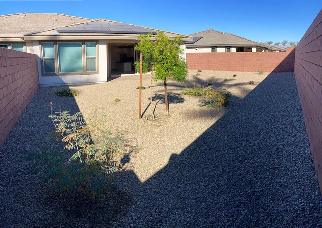 a view of a backyard with plants and a patio