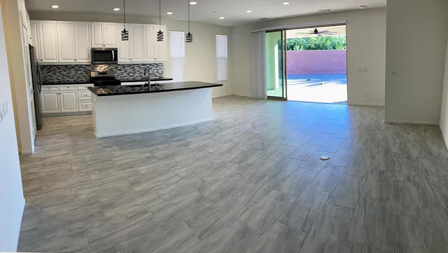 a kitchen with granite countertop a sink a counter top space and cabinets