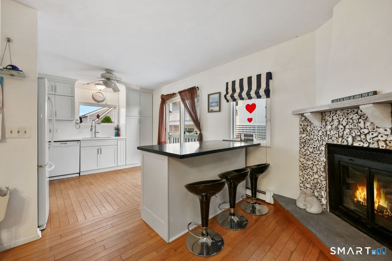 6 Lighthouse Point Fairfield, CT 06824 - Photo 16 of 40 a living room with furniture and a fireplace