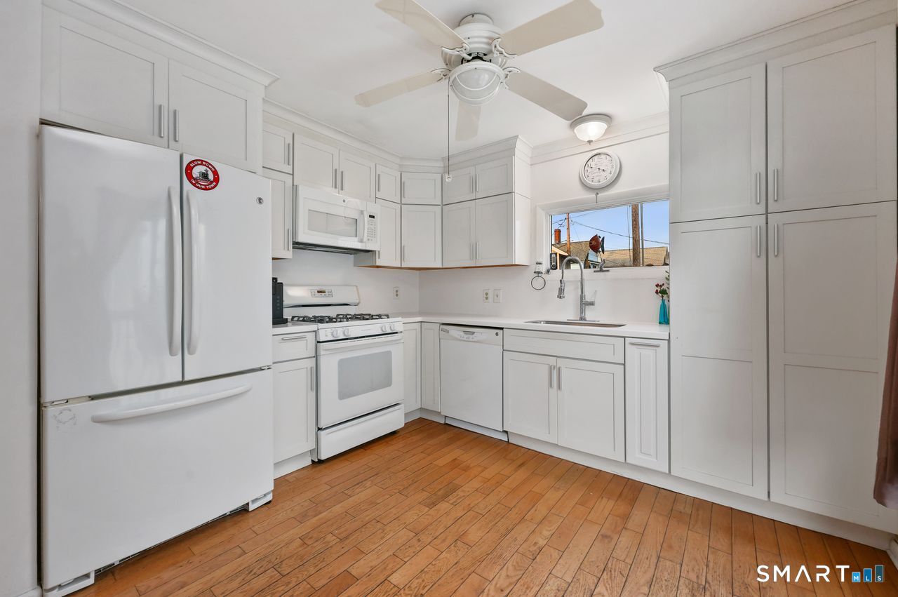 6 Lighthouse Point Fairfield, CT 06824 - Photo 17 of 40 a kitchen with white cabinets and white appliances