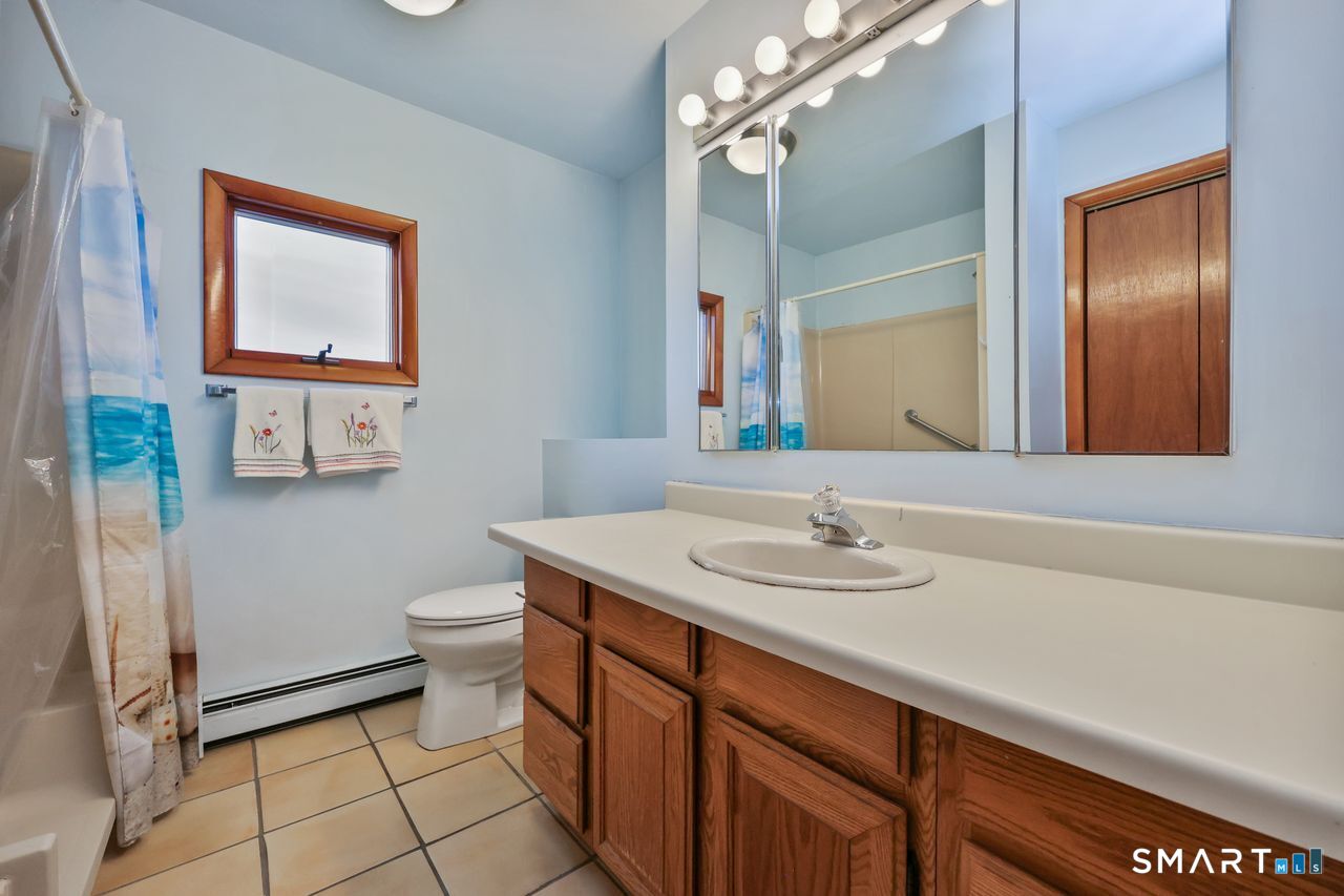 6 Lighthouse Point Fairfield, CT 06824 - Photo 28 of 40 a bathroom with a sink a toilet a mirror and shower