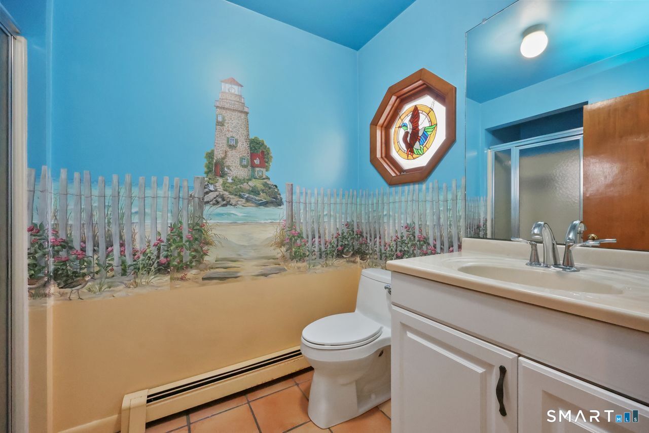 6 Lighthouse Point Fairfield, CT 06824 - Photo 31 of 40 a bathroom with a toilet sink vanity and mirror