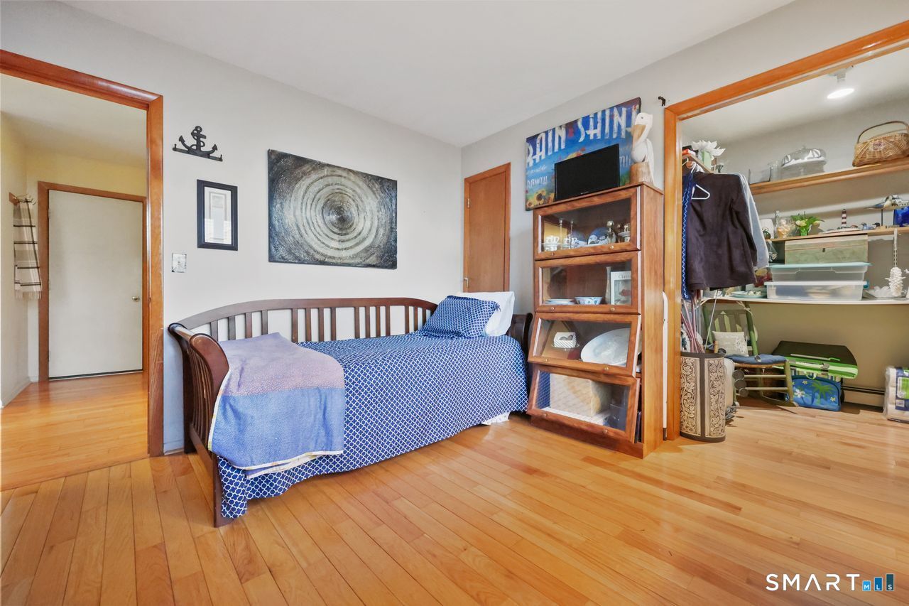 6 Lighthouse Point Fairfield, CT 06824 - Photo 33 of 40 a bedroom with furniture and a book shelf