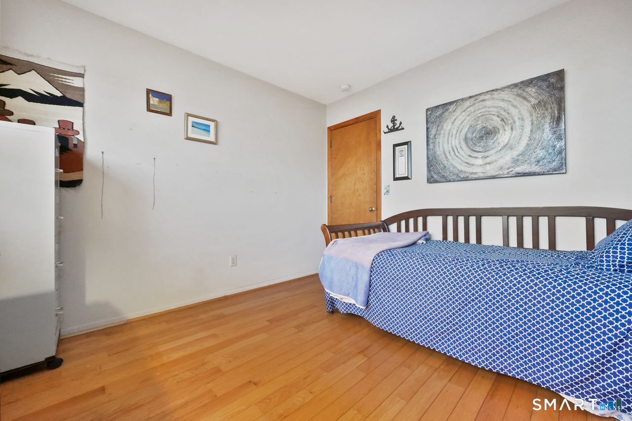 6 Lighthouse Point Fairfield, CT 06824 - Photo 34 of 40 a bedroom with a bed painting on the wall and a window