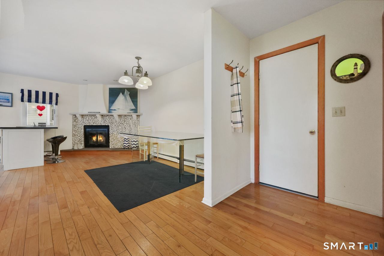6 Lighthouse Point Fairfield, CT 06824 - Photo 7 of 40 an empty room with wooden floor fireplace and windows