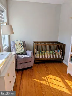 a living room with furniture and a baby crib