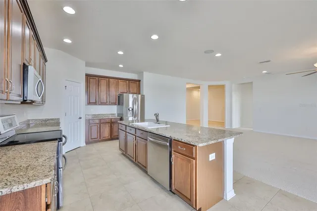 a large kitchen with a large counter top appliances and cabinets
