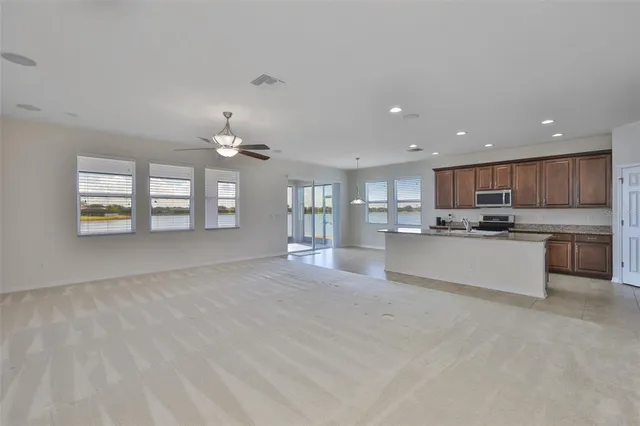 a view of an empty room with a chandelier fan