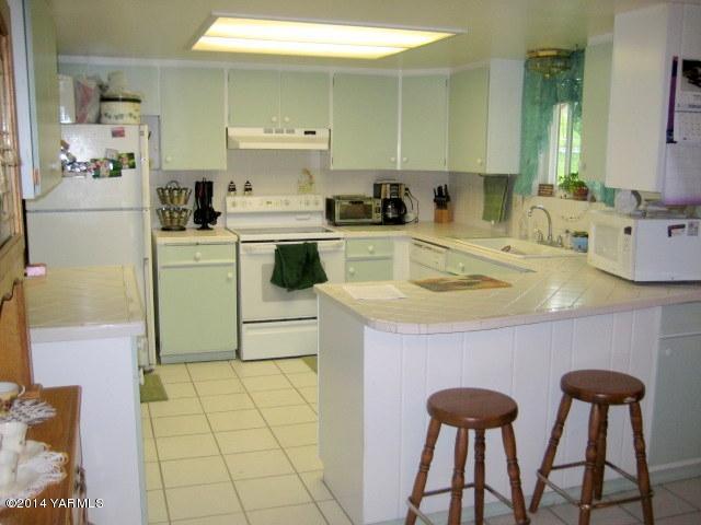 1880 Pleasant Hill Road Selah, WA 98942 - Photo 5 of 20 a kitchen with a sink a stove cabinets and chairs