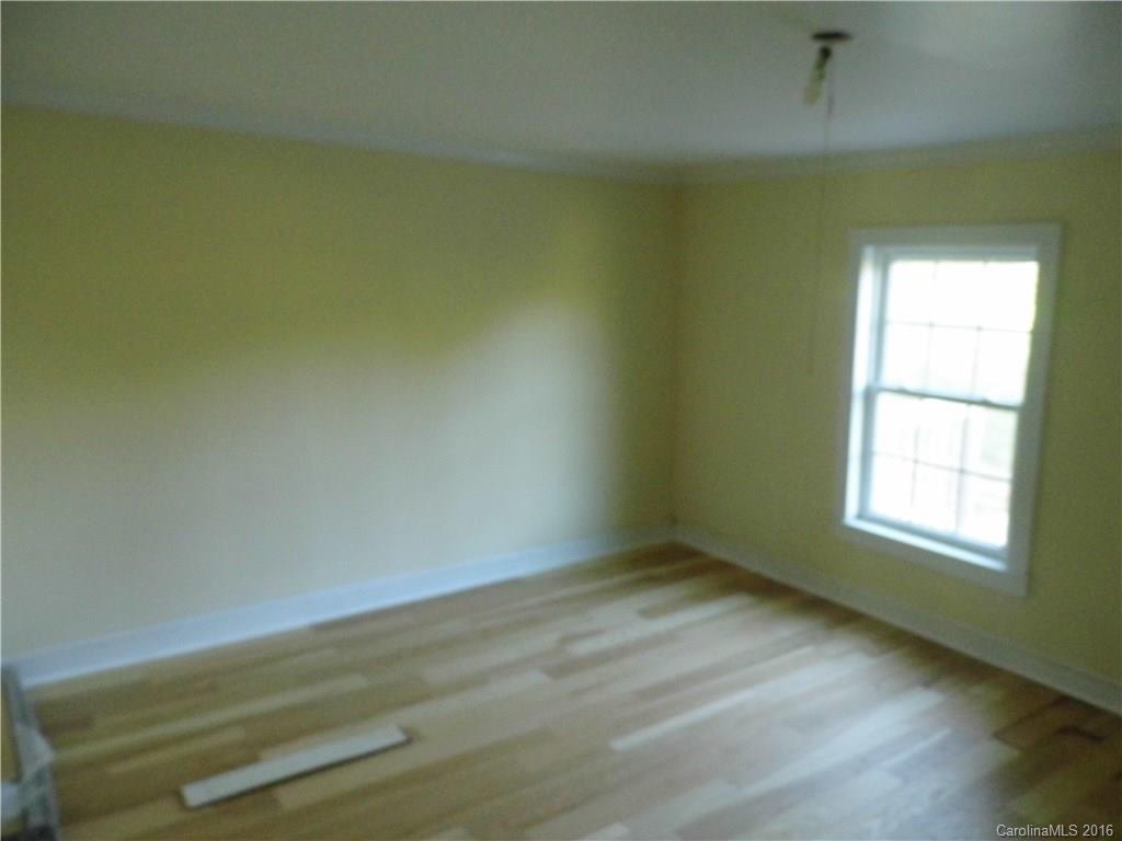 8376 Smith Road Stanfield, NC 28163 - Photo 9 of 15 an empty room with wooden floor and windows