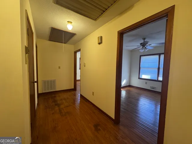 a view of a hallway with wooden floor