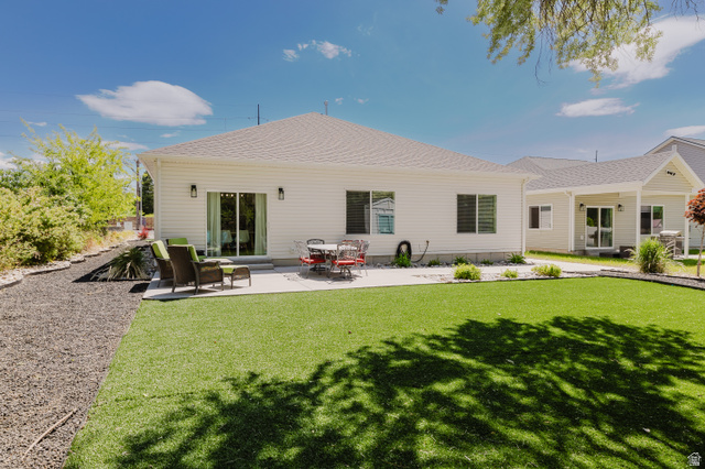 287 East 1000 North Logan, UT 84321 - Photo 37 of 41 Expansive backyard featuring a lush green lawn, a concrete patio, and a covered patio area