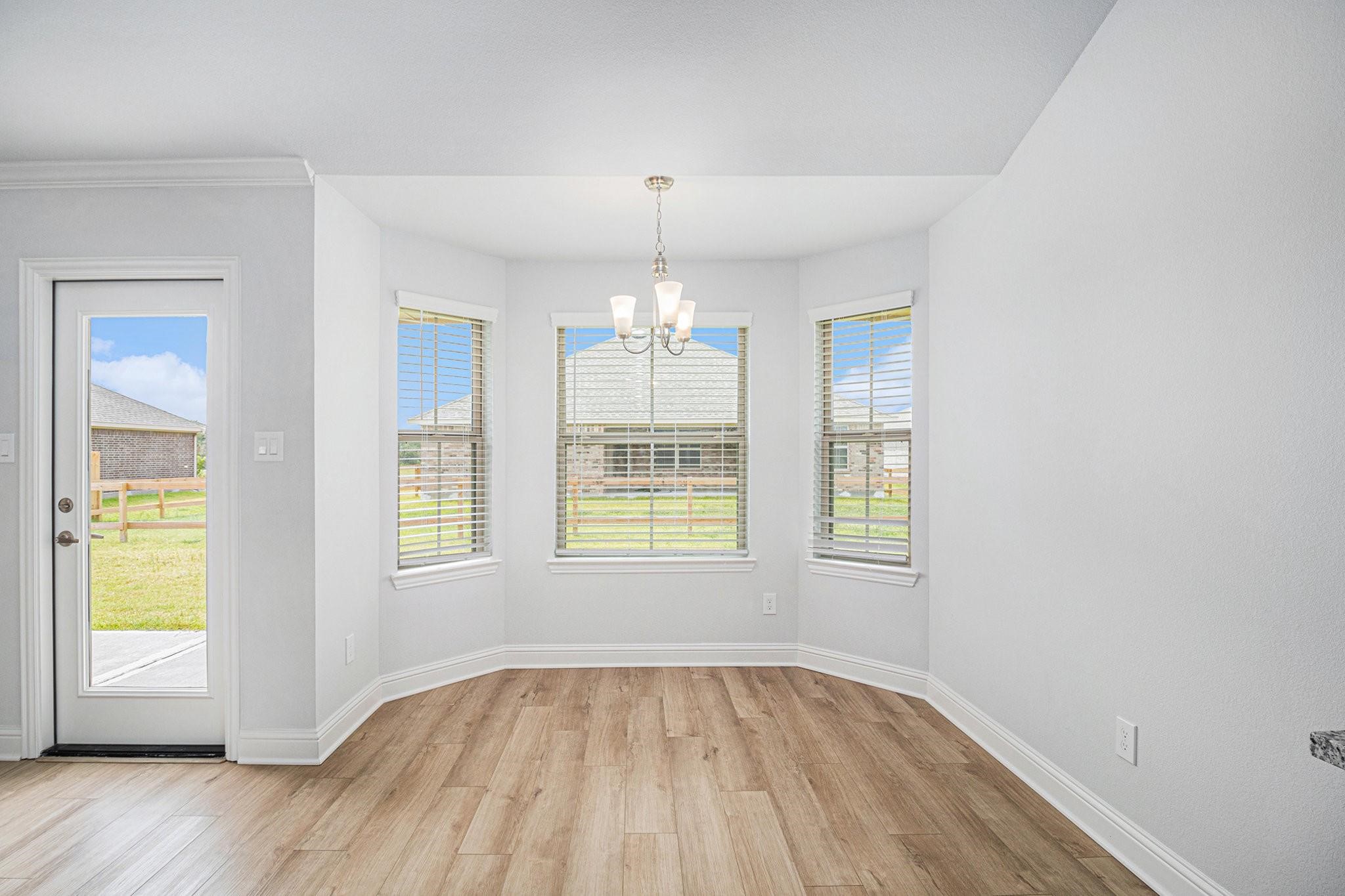 10 Greystone Court Angleton, TX 77515 - Photo 3 of 10 an empty room with wooden floor and windows