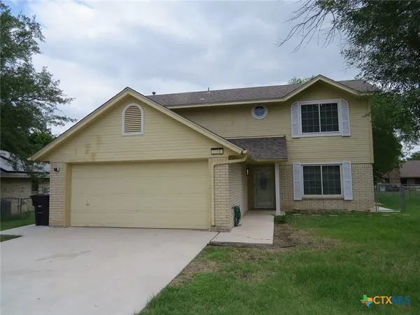a front view of a house with a garden and yard