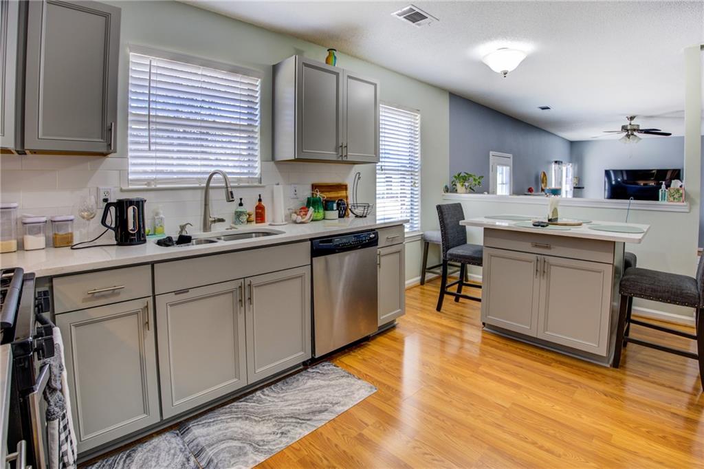 4885 Hidden Creek Place Decatur, GA 30035 - Photo 12 of 52 a kitchen with stainless steel appliances granite countertop wooden cabinets a sink a stove a dining table and chairs