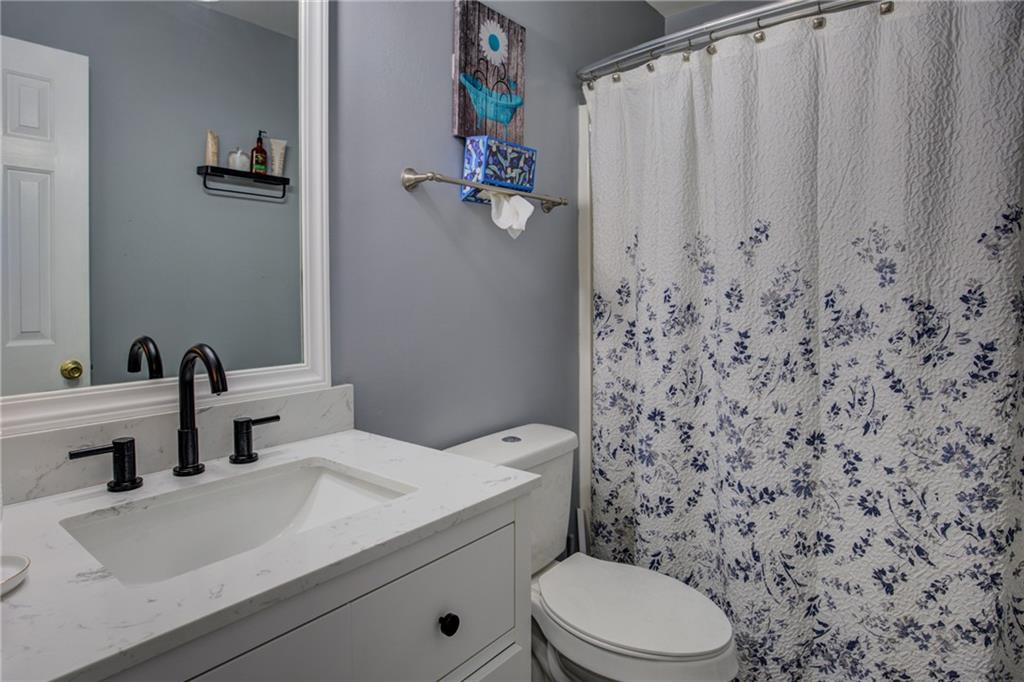 4885 Hidden Creek Place Decatur, GA 30035 - Photo 33 of 52 a bathroom with a sink a toilet and shower curtain