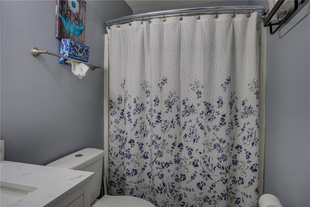 4885 Hidden Creek Place Decatur, GA 30035 - Photo 34 of 52 a bathroom with a toilet and a shower curtain