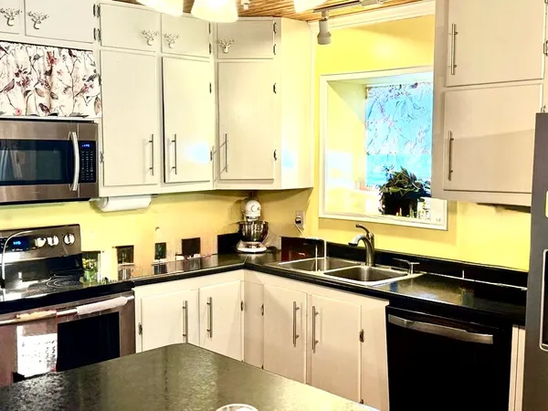 a kitchen with stainless steel appliances granite countertop a sink a stove and microwave