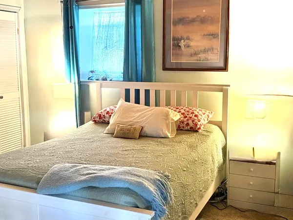 a bedroom with a bed and with painting on the wall