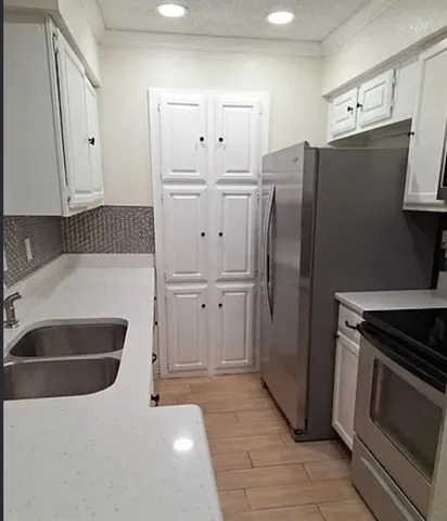 a kitchen with stainless steel appliances a refrigerator stove and cabinets