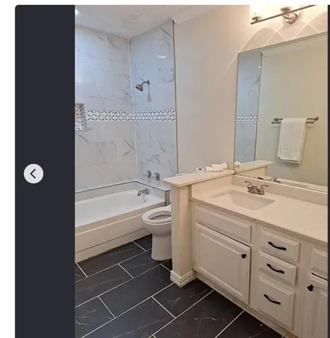 a bathroom with a double vanity sink a toilet and a bathtub