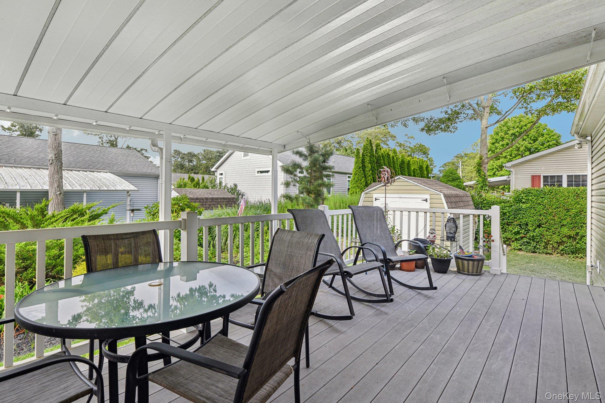 1661 Old Country Road, Unit 543 Riverhead, NY 11901 - Photo 18 of 26 Wooden deck with outdoor dining area and an outdoor structure