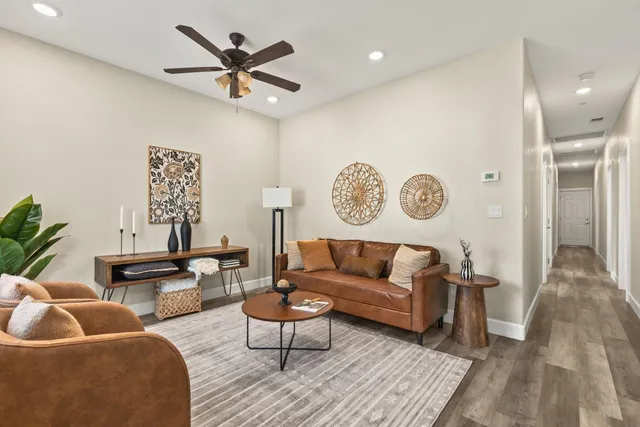 a living room with furniture and a wooden floor