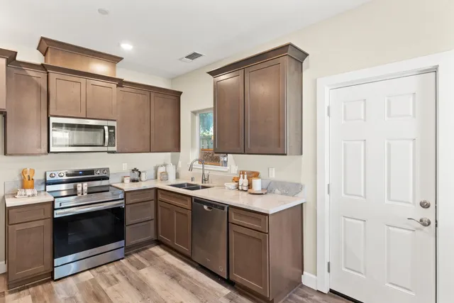 a kitchen with stainless steel appliances a stove and a microwave