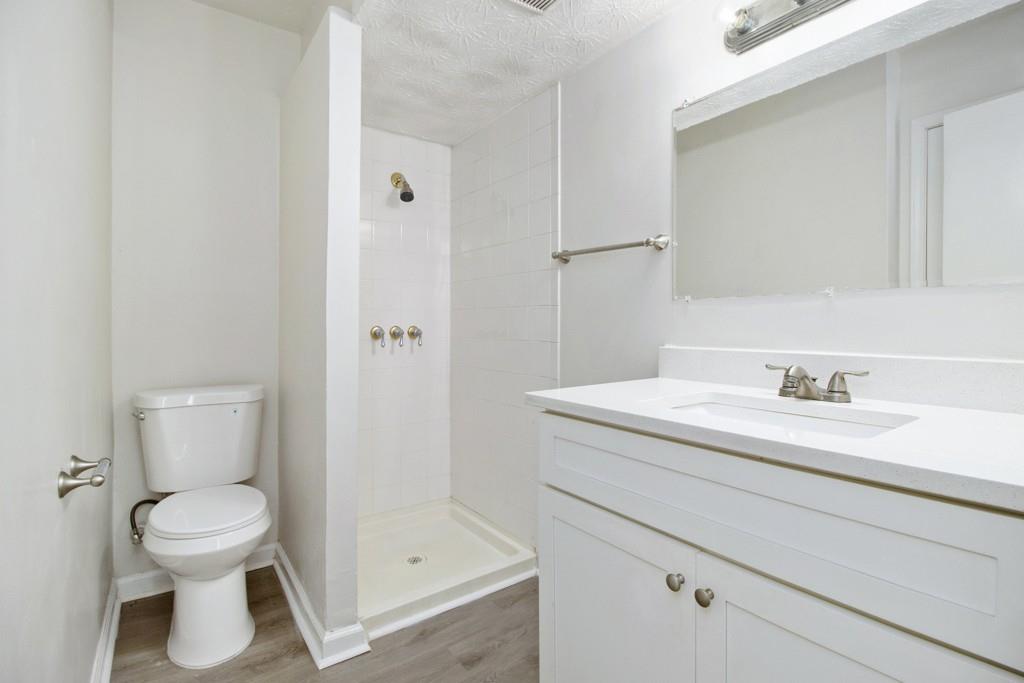 5774 Taffeta Court Lithonia, GA 30058 - Photo 14 of 25 a bathroom with a granite countertop sink toilet and shower