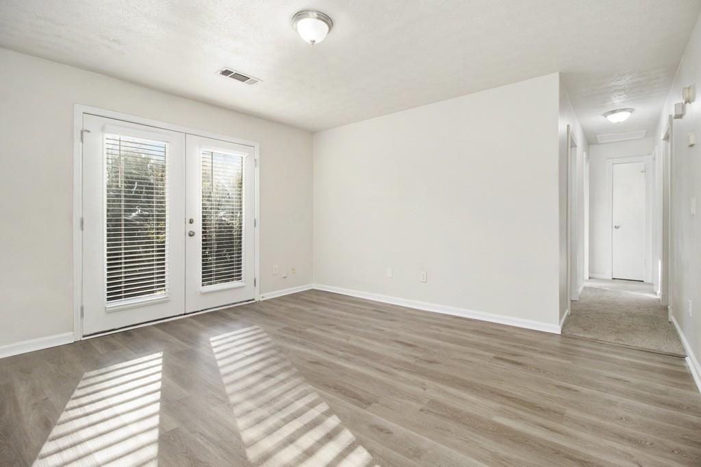 5774 Taffeta Court Lithonia, GA 30058 - Photo 5 of 25 a view of an empty room with wooden floor and a window