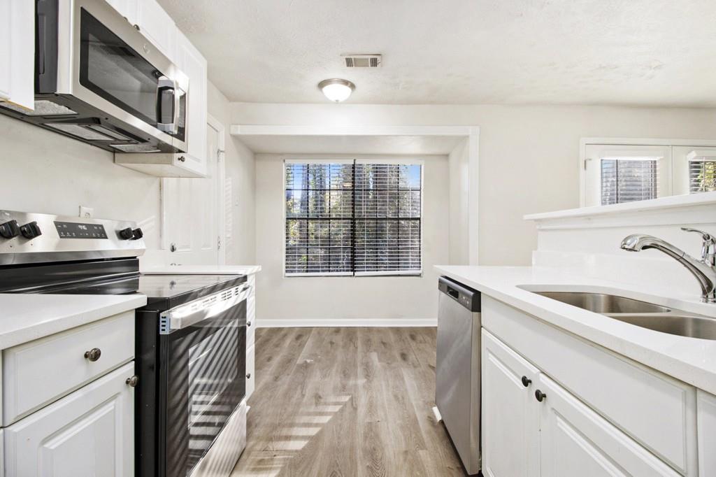5774 Taffeta Court Lithonia, GA 30058 - Photo 10 of 25 a kitchen with stainless steel appliances granite countertop a sink and a stove